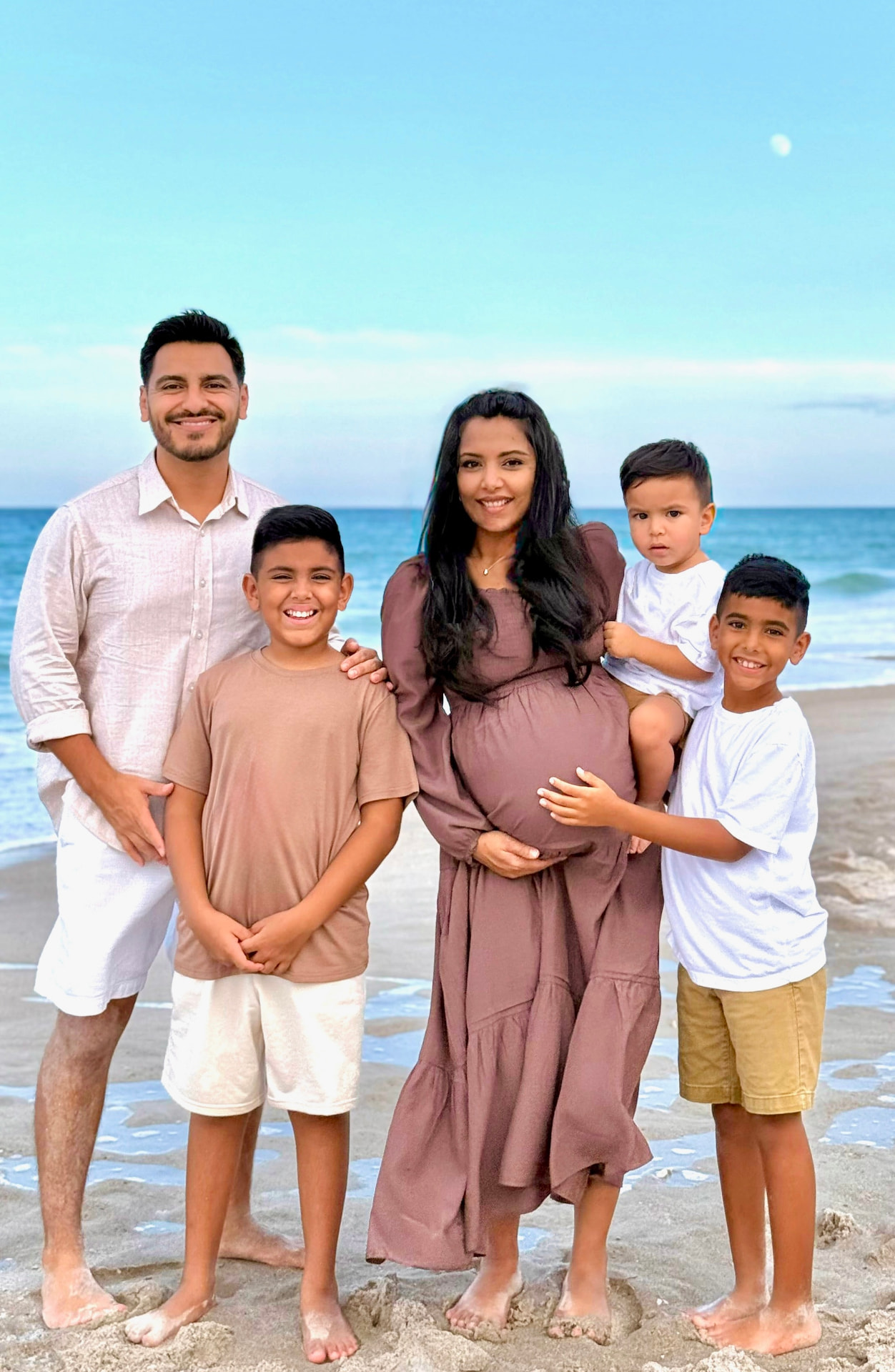Eddie with his wife and three of their sons at the beach during her pregnancy.