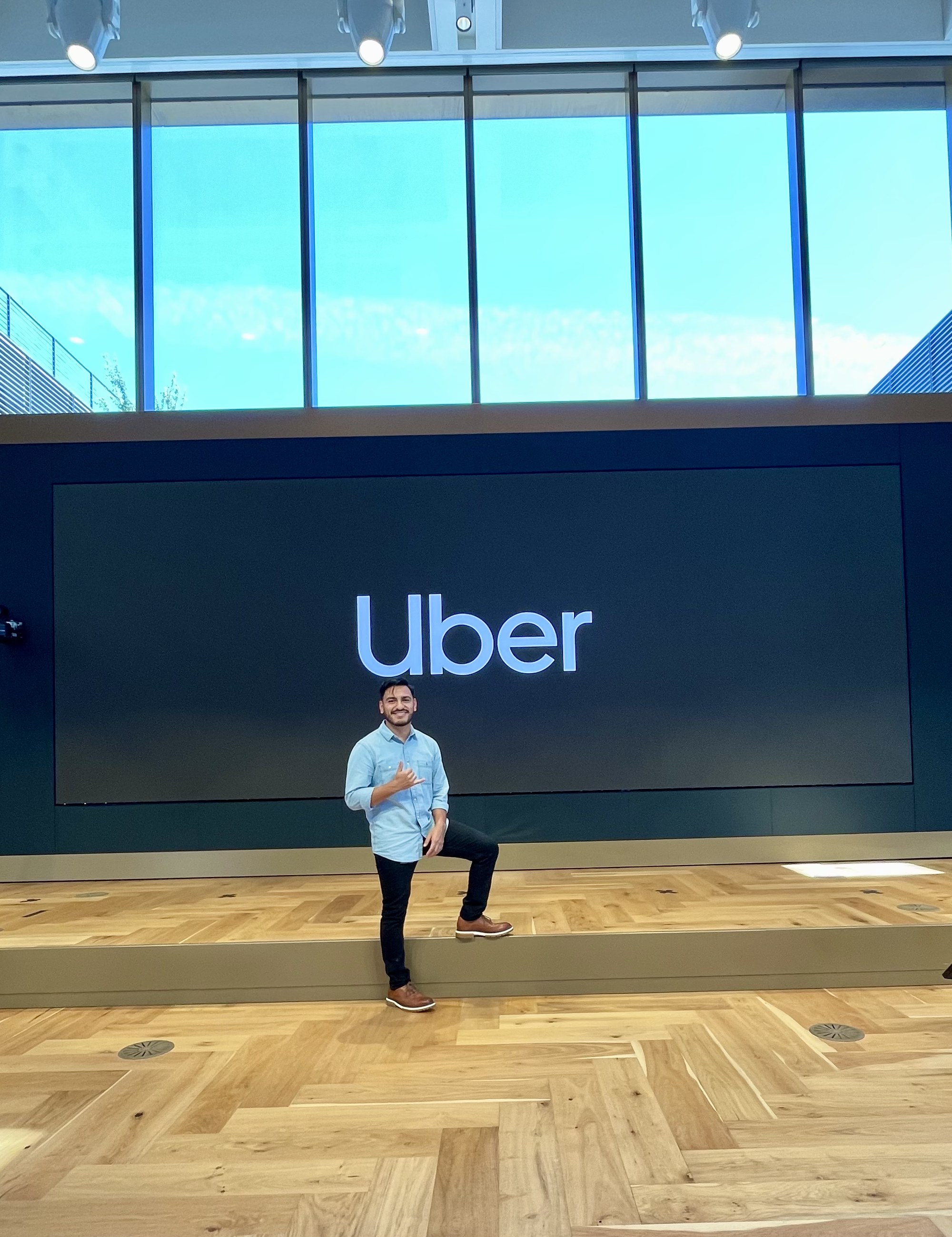 Eddie in front of the Uber logo at the company's headquarters.