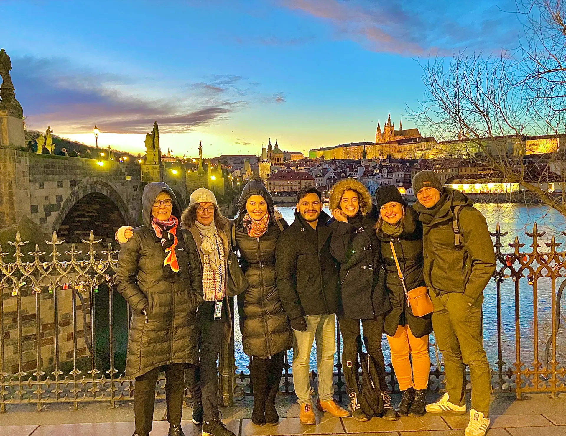 Eddie with colleagues on a bridge overlooking a city at sunset.